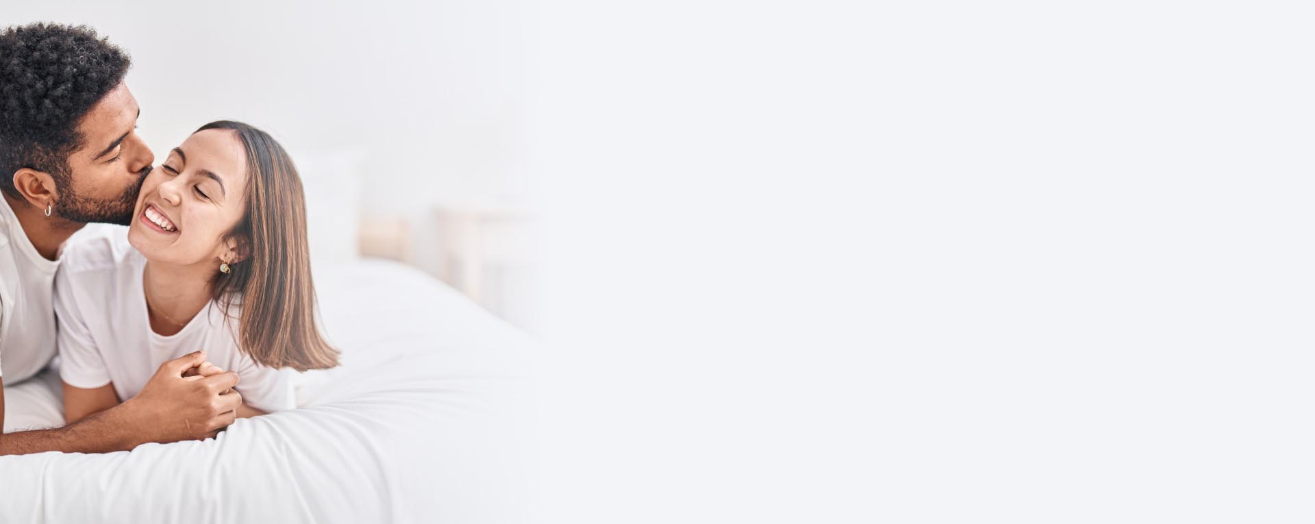 Happy couple embracing in bed, representing enhanced intimacy from an O-Shot treatment in NYC